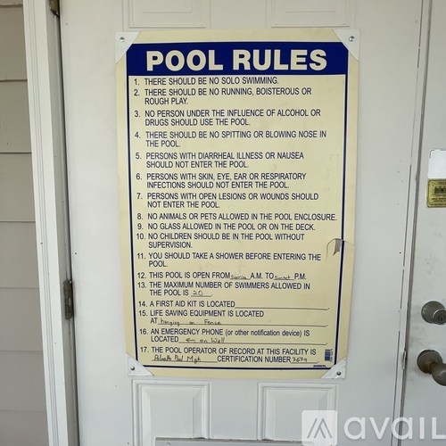 A pool rules sign posted on a door.