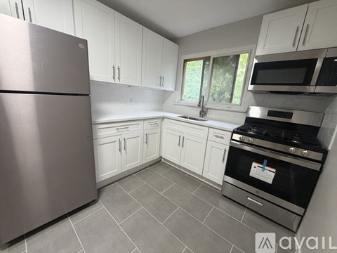 A kitchen with a refrigerator, oven, and microwave.