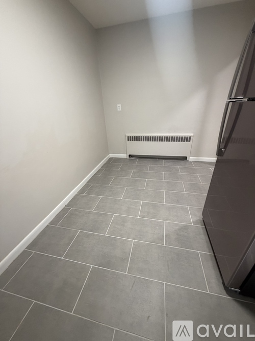 A room with a tiled floor and a wall-mounted radiator.