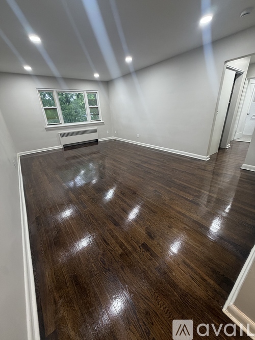 A room with wooden flooring and a window.