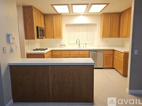 A kitchen with wooden cabinets and a stainless steel dishwasher.