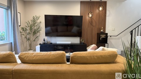 A living room with a yellow sofa and a television.