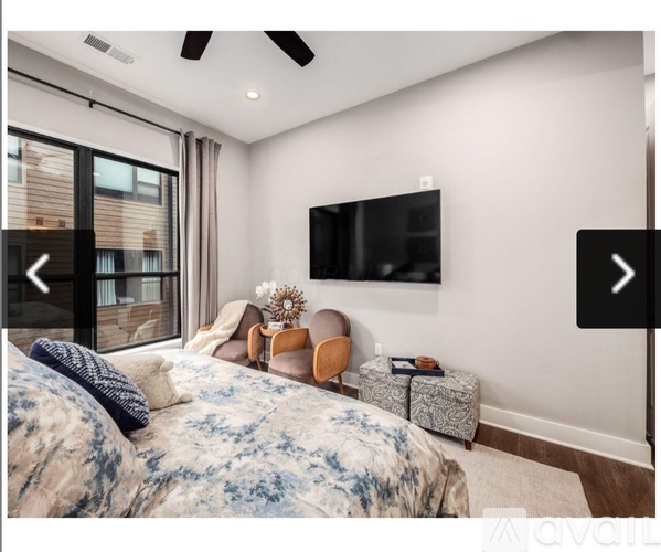 A bedroom with a large bed and a flat screen TV mounted on the wall.