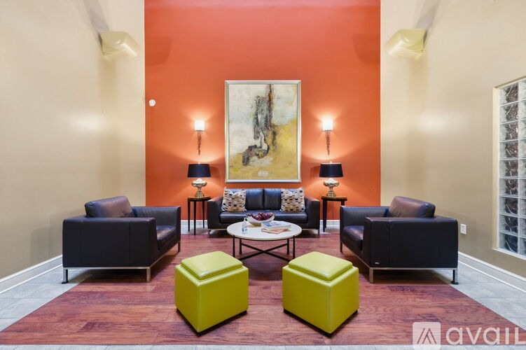 A living room with a large painting on the wall and a coffee table in the center.