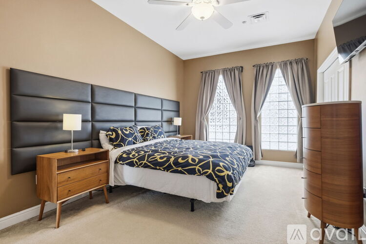A bedroom with a bed, nightstand, and window.