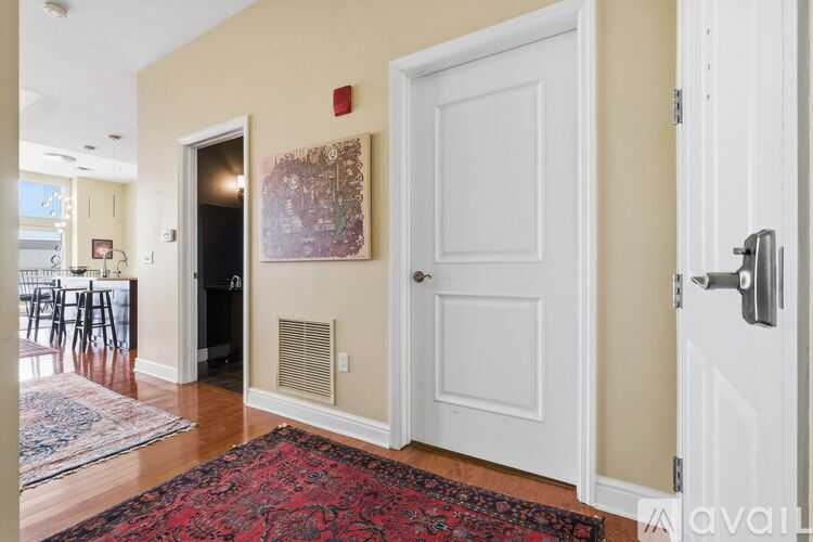 A room with a red rug and a white door.