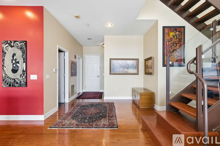 A hallway with a red wall and a rug on the floor.