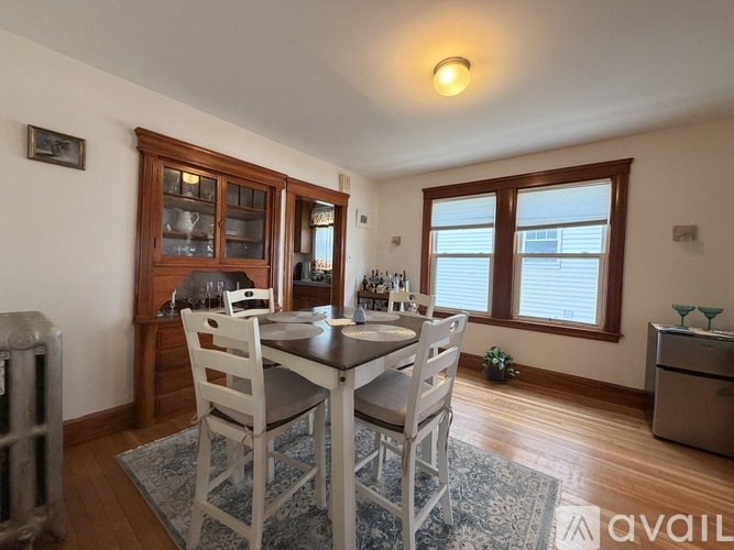 A dining room with a table set for two and a window with blinds.