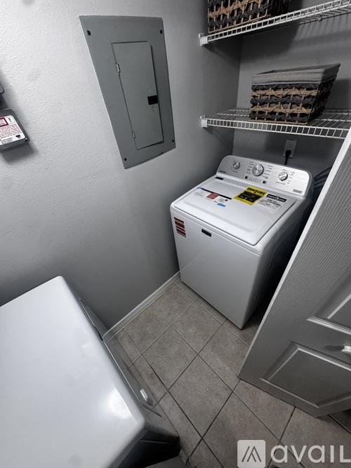 A white washing machine in a small laundry room.