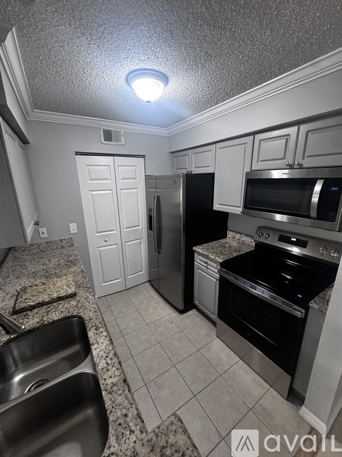 A kitchen with a sink, stove, and refrigerator.