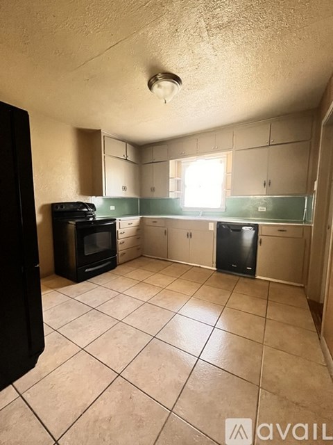 A kitchen with black appliances and white cabinets.