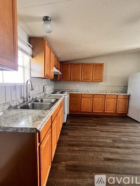 A kitchen with wooden cabinets and a white refrigerator.