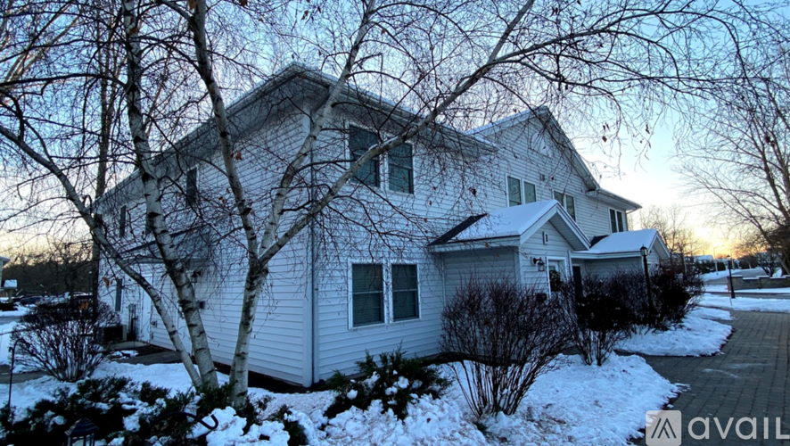 A house with a white exterior and snow on the ground.