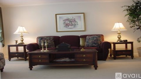 A living room with a couch, two lamps, and a painting on the wall.