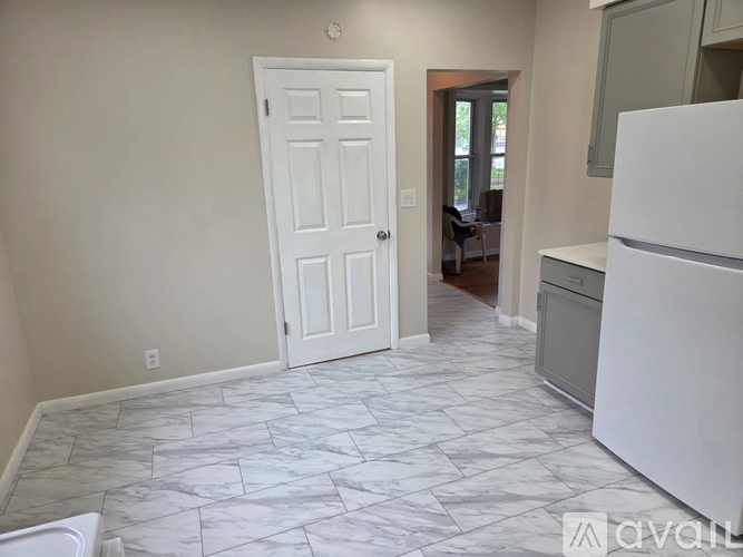 A kitchen with a white fridge and a white door.