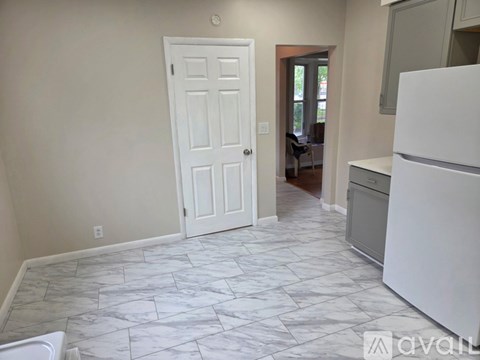 A kitchen with a white fridge and a white door.