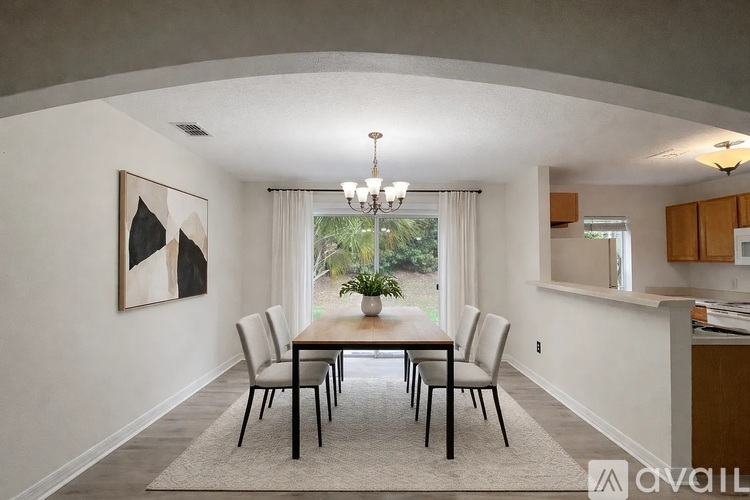 A dining room with a large table and chairs.