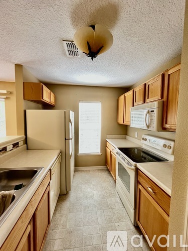 A kitchen with wooden cabinets and a white refrigerator.