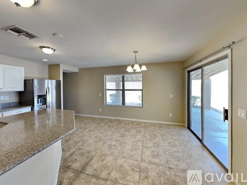 A kitchen with granite countertops and a refrigerator.