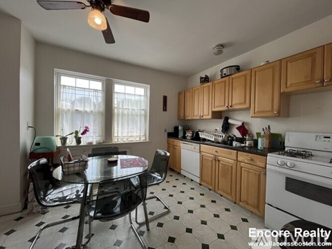 A kitchen with a table and chairs in front of a window.