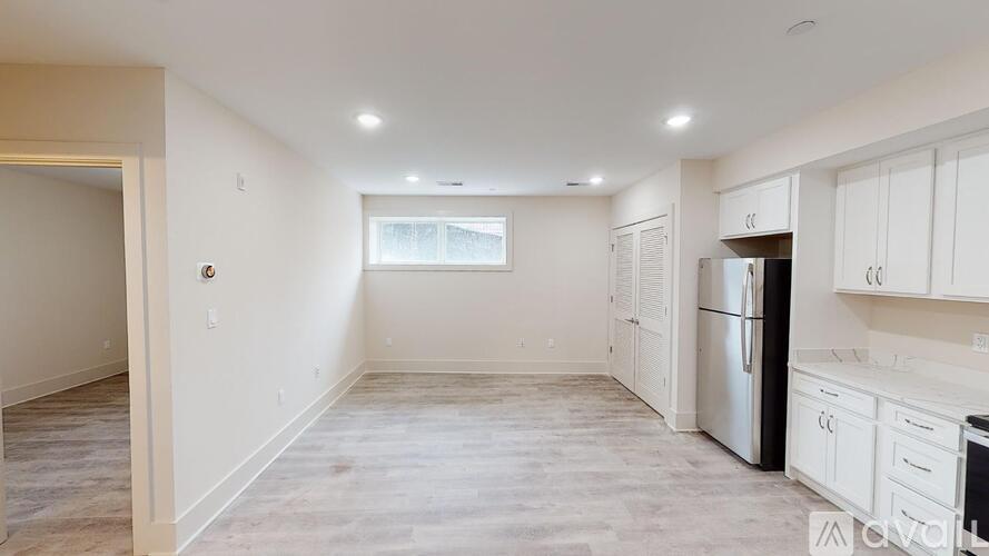 A kitchen with white cabinets and a stainless steel refrigerator.