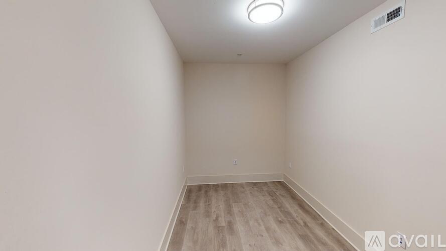 A room with wooden flooring and a light on the ceiling.