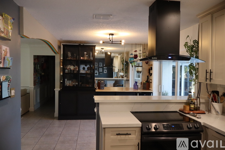 A kitchen with black cabinets and a white countertop.