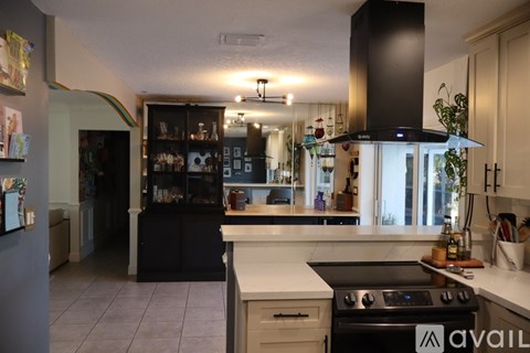 A kitchen with black cabinets and a white countertop.
