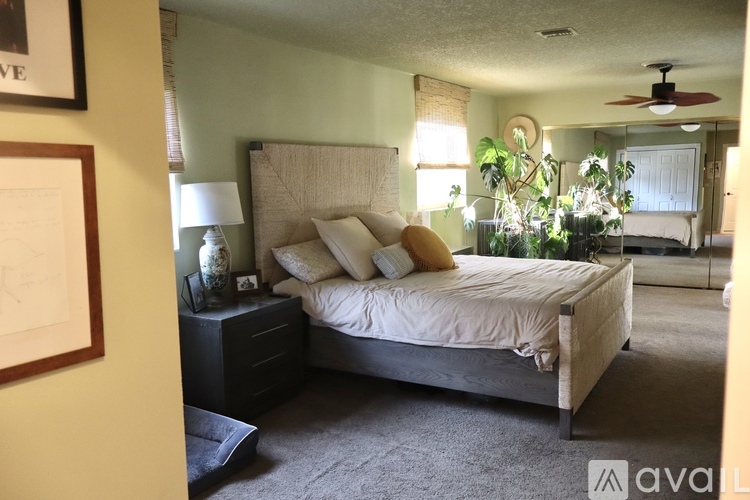 A bedroom with a large bed and a ceiling fan.
