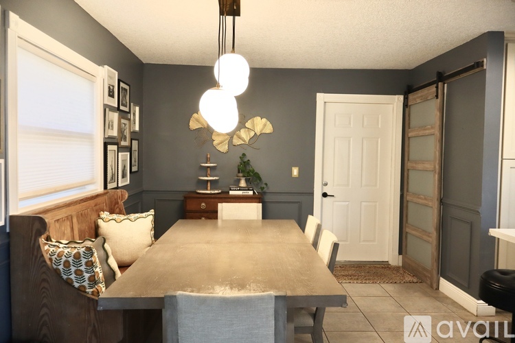 A dining room with a wooden table and chairs.