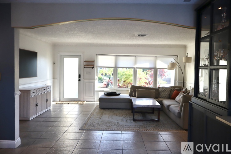A living room with a couch, a coffee table, and a television.