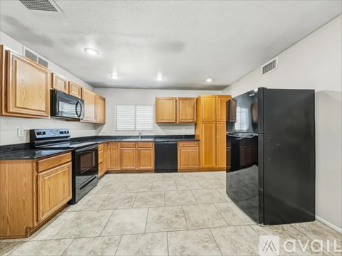 A kitchen with wooden cabinets and black appliances.