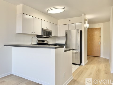 A kitchen with white cabinets and a wooden door.