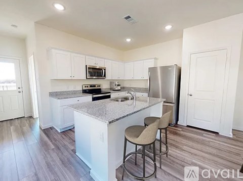A kitchen with white cabinets and a granite countertop.
