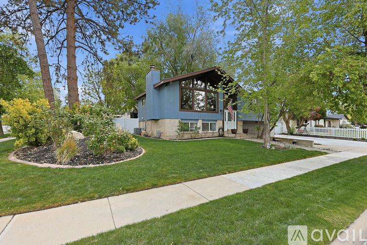 A house with a well-maintained lawn and trees in the background.