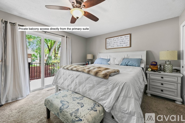 A bedroom with a bed, dresser, and a ceiling fan with a private balcony access.