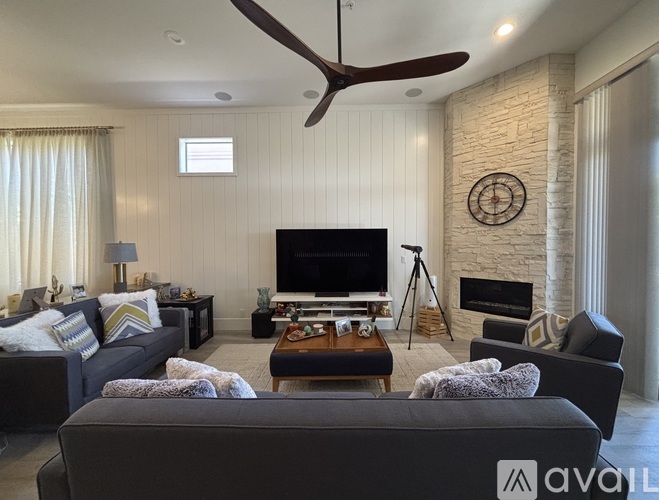 A living room with a grey couch and a black television.