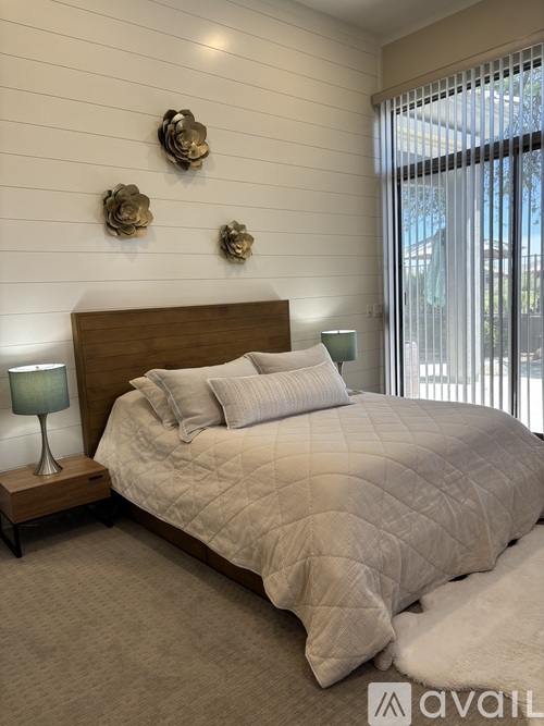 A bedroom with a large bed and three decorative items on the wall.