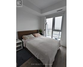A bedroom with a large bed and a window overlooking the street.