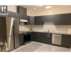 A modern kitchen with a refrigerator, oven, and sink.