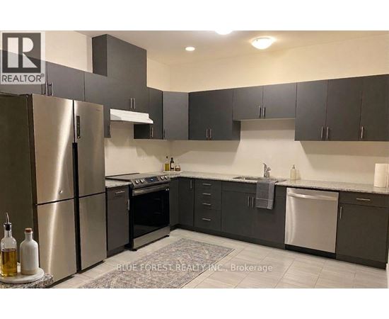 A modern kitchen with a refrigerator, oven, and sink.