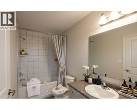 A bathroom with a white tub, sink, and toilet.