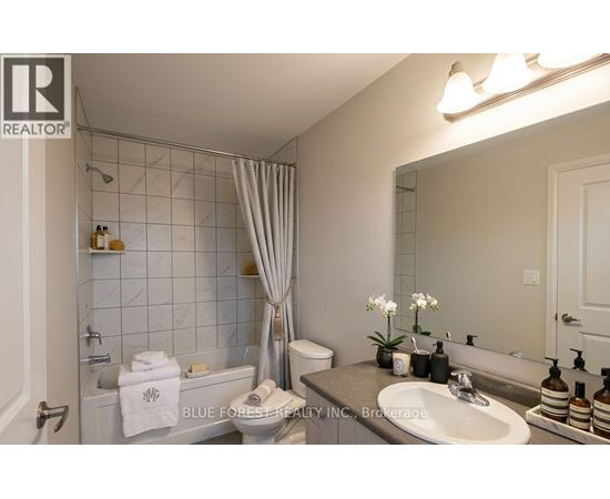 A bathroom with a white tub, sink, and toilet.