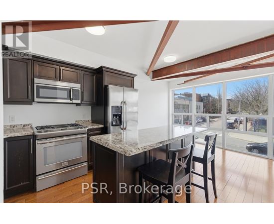 A kitchen with brown cabinets and a granite countertop.