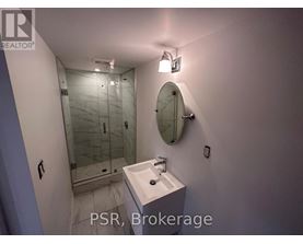 A bathroom with a sink, mirror, and shower.