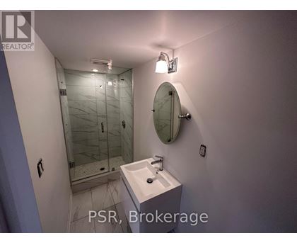 A bathroom with a sink, mirror, and shower.
