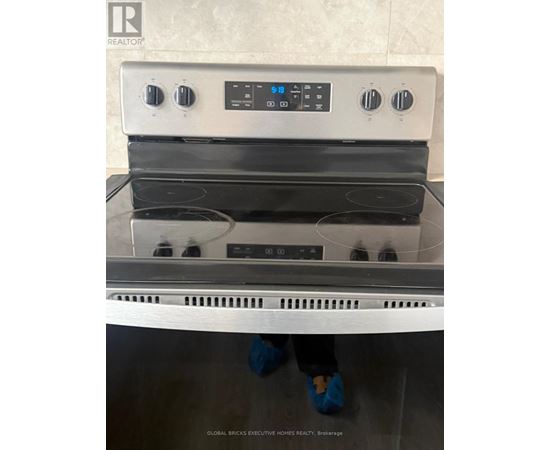 A stainless steel oven with a digital control panel and four burners.