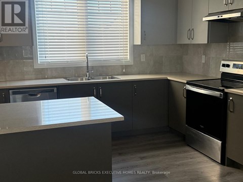A kitchen with a stainless steel oven and sink.