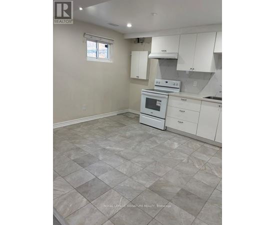 A kitchen with white cabinets and a tiled floor.