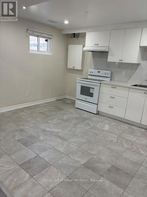 A kitchen with white cabinets and a tiled floor.
